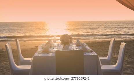 Romantic dinner table setting on the beach at sunset view scene with romantic dinner set up background