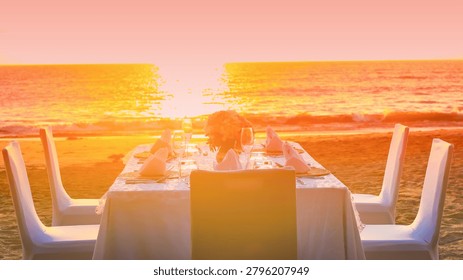 Romantic dinner table setting on the beach at sunset view scene with romantic dinner set up background