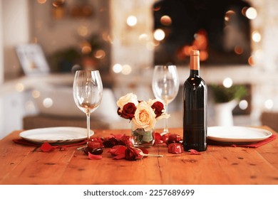 Romantic, dinner table and setup for valentines day, fine dining or date at indoor night restaurant. Interior diner with wine glasses prepared with roses and champagne for evening couple reservation