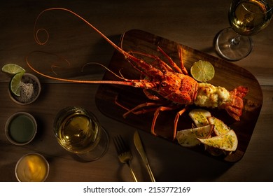 Romantic Dinner For Two. Red Lobster With Croutons And Sauce And Two Glasses Of White Wine On A Wooden Surface Top View