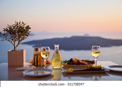 Romantic dinner for two at sunset.Greece, Santorini, restaurant on the beach, above the volcano. 