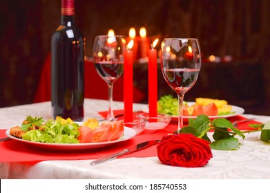 Romantic Dinner With Wine, Candles And A Red Rose On A Table