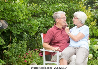 An Romantic Elderly Couple Sitting Outside And Looking Lovingly At Each Other