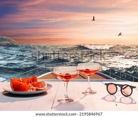 Romantic evening sea trip. Cocktail glasses, fruit on deck of private yacht during honeymoon holidays, outdoors. Vacation, dating, love, travel, vivid impressions. Design for wallpaper, poster