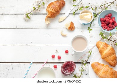 Romantic french or rural breakfast - cocoa, milk, croissants, jam, butter and raspberries on rustic white wooden table from above. Countryside weekend concept. Background layout with free text space. - Powered by Shutterstock