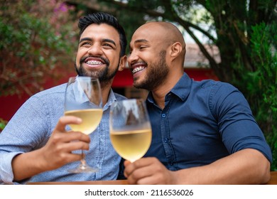 Romantic Gay Couple Smiling And Drinking Wine In Table Outside