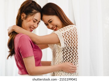 Romantic Gay Lesbians Holding Each Other Smiling. Beautiful Sensual Asian Homosexual Couple Intimate Moment Embracing In Bedroom By Window. Portrait Of Two Women Hugging With Affectionate Relationship