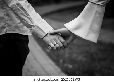 Romantic Gesture in Black and White: A Couple Holding Hands in a Serene Park Setting. - Powered by Shutterstock