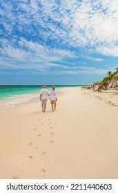 Romantic Getaway For Healthy Retired Caucasian Couple Walking Together On Tropical Beach Leaving Footprints In Sand Bahamas