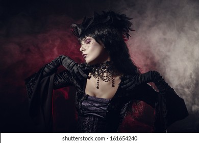 Romantic gothic girl in Victorian style clothes, shot over smoky background 