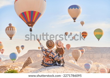Romantic happy traveling couple hugging together and makes wish in scenic valley in Anatolia, Kapadokya. Beautiful destination in Nevsehir, Goreme