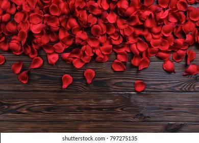 Romantic happy valentines day greeting card / women's day, wedding invitation. Dark wooden textured floor background half covered with red, scarlet, crimson rose petals. Close up, top view, copy space - Powered by Shutterstock