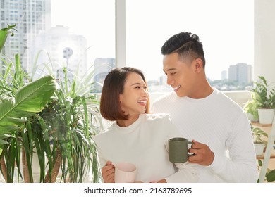 romantic happy young couple enjoying morning coffee by the window on bright day at home - Powered by Shutterstock