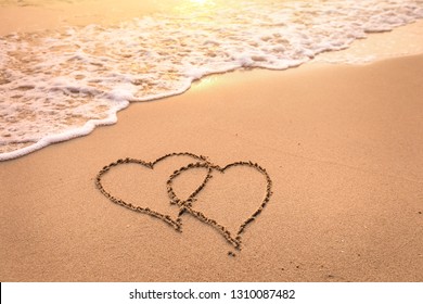 Romantic Honeymoon Holiday Or Valentine's Day On The Beach Concept With Two Hearts Drawn On The Sand, Tropical Getaway For Couples, Love Symbol