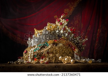 Romantic image of a treasure chest filled with jewellery, precious gems and golden king's crowns