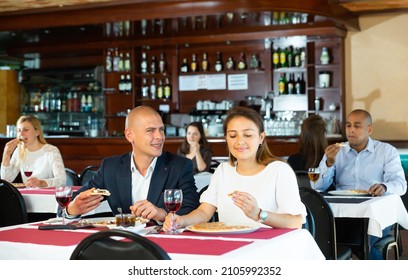 Romantic Interracial Couple Enjoying Dinner With Delicious Pizza And Wine In Cozy Italian Restaurant