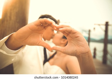 Romantic love Asia couple with wedding dress. Royalty high-quality free stock image of romantic love couple kissing, hands holding making heart shape with hands. Romance young asia couple wedding 