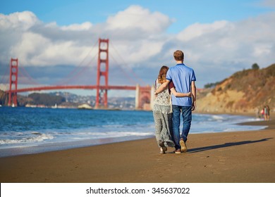 Romantic loving couple having a date on Baker beach in San Francisco, California, USA. Golden gate bridge in the background - Powered by Shutterstock