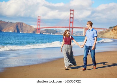 Romantic loving couple having a date on Baker beach in San Francisco, California, USA. Golden gate bridge in the background - Powered by Shutterstock