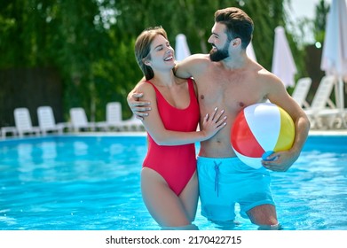 Romantic man embracing his female companion in the swimming pool - Powered by Shutterstock