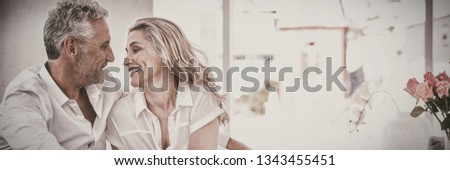 Romantic mature couple sitting face to face at home