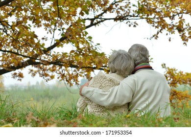 Romantic Mature Couple Is Sitting In The Park In Fall