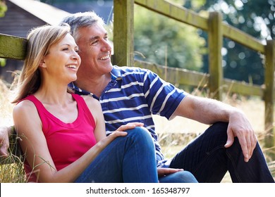 Romantic Middle Aged Couple Relaxing On Walk In Countryside