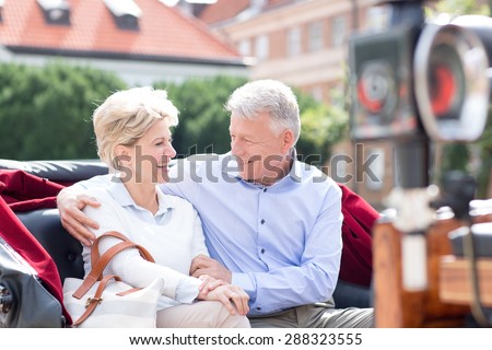Romantic middle-aged couple sitting in horse cart