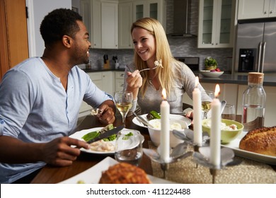 Romantic Mixed Race Couple Eating Evening Meal In Kitchen