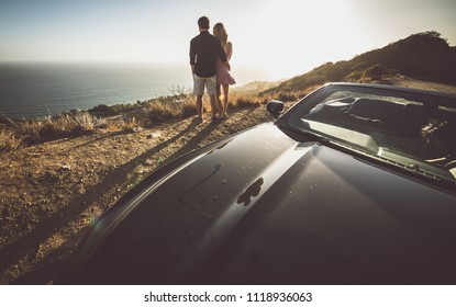 Romantic Moment On The Cliff In Malibu. Couple Watching Panorama From Their Car