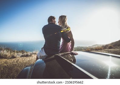 Romantic moment on the cliff in Malibu. Couple watching panorama from their car
