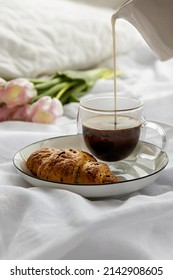 Romantic morning cup of coffee with a croissant on white plate in a bedroom. Breakfast on a bed. - Shutterstock ID 2142908605