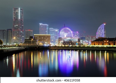 Romantic night scenery of Yokohama Minatomirai Bay area with view of high rise skyscrapers in the background, a giant Ferris wheel in the Amusement Park & reflections of colorful city lights on water - Powered by Shutterstock