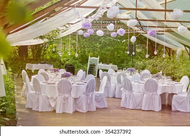 Romantic Outdoor Wedding In The Old Greenhouse- White Tablecloth, Empty Glasses, White Table Setting, Wild Fresh Flowers