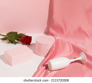 Romantic Pastel Pink Valentine's Day Composition With Wine Glass, Satin Curtain And Red Rose Flower. Suitable For Product Display And Business Concept. Modern Aesthetic.