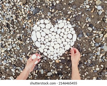 Romantic Photo With Nature Abstract Design Of White Stones, Pebbles. Heart Shape, Symbol On The Beach. Woman Making Art