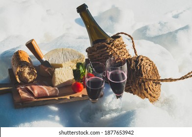 Romantic Picnic With Lambrusco Cheese Baguette And Ham On Snow. Traditional Italian Food And Drink In Sunny Winter Day.