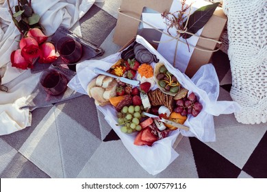 Romantic Picnic Set Up With Mixed Food Platter And Wine At Sunset