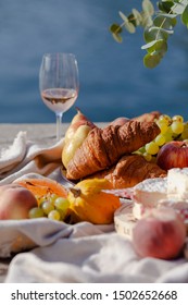 Romantic Picnic For Two On The Quay Of Seine River In Paris. Parisien Elegancy And Chic. Traditional French Croissants, Cheese, Fruits And Glasses Of Wine. Bright Sunshine, Good Weather, Happy Mood