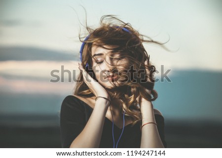 Young redhead woman listening to music