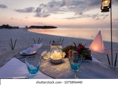 Romantic, Private Dinner Setup At A Tropical Beach During Sunset Time