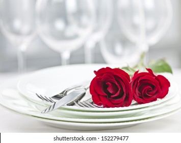 Romantic Restaurant Table Setting For Two With Roses Plates And Cutlery