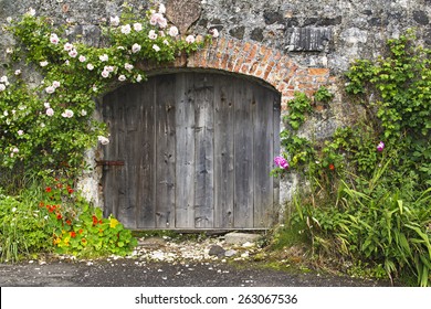 Romantic rustic stone and brick, rose covered wall and stable doors in a Northern Ireland, UK village.  - Powered by Shutterstock