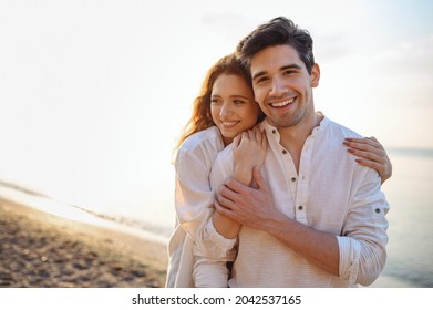 Romantic satisfied sunlit smiling happy young couple two friends family man woman in casual clothes hug each other at sunrise over sea beach ocean outdoor exotic seaside in summer day sunset evening - Shutterstock ID 2042537165