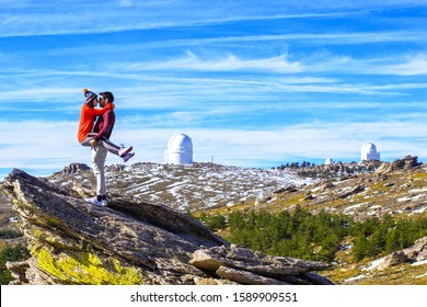 Romantic scene of a couple watching the view and kissing at mountain top in Calar Alto Observatory, Almeria, Andalusia, Spain