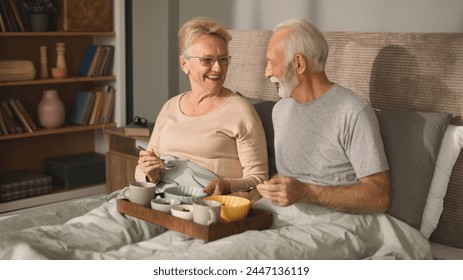 Romantic senior couple having breakfast in bed - Powered by Shutterstock