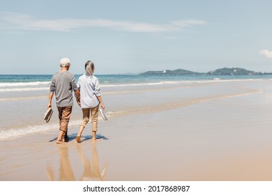 Romantic Senior couple strolling happily along the beach in the sunshine and bright sky. Plan life insurance and retirement concept. - Powered by Shutterstock