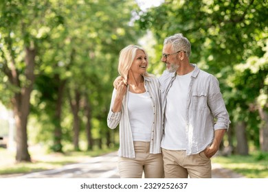 Romantic Senior Couple Walking Outdoors In Summer Park And Embracing, Loving Happy Mature Spouses Hugging And Smiling To Each Other, Cheerful Husband And Wife Enjoying Outside Walk, Copy Space - Powered by Shutterstock