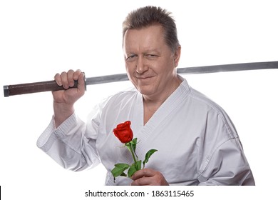 Romantic senior gentleman holding rose and samurai sword dressed in traditional white kimono. War and Peace concept. isolated on white background.