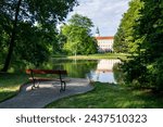 A romantic spot with wooden bench by the pond in the Chateau Garden with a view of the Archbishop